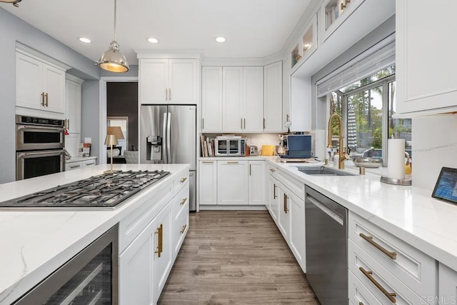 4520 Tarantella Ln, San Diego, CA 92130 - kitchen with stainless steel appliances, beverage cooler, a sink, white cabinetry, and recessed lighting