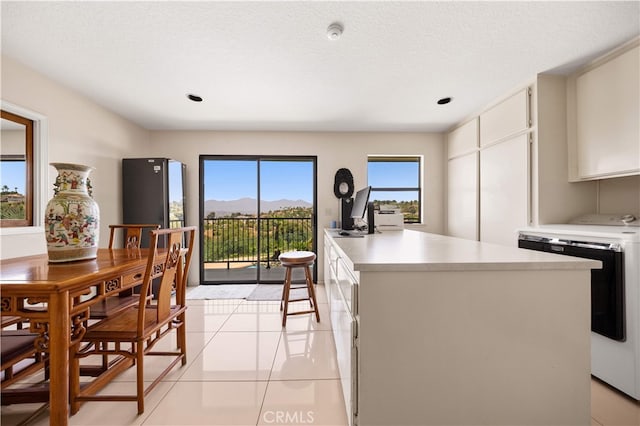 2360 Oakleaf Canyon Rd, Walnut, CA 91789 - kitchen featuring light countertops, light tile patterned flooring, white cabinets, washer and clothes dryer, and recessed lighting