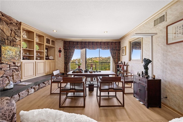 2360 Oakleaf Canyon Rd, Walnut, CA 91789 - dining room featuring ornamental molding, light wood-style floors, and a textured ceiling