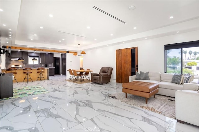 22940 Sherman Way, West Hills, CA 91307 - living room featuring a tray ceiling, recessed lighting, and light marble finish floors