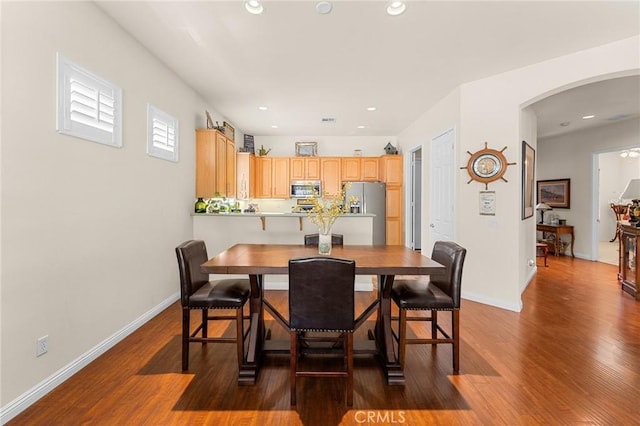 1574 Litchfield Ct, Banning, CA 92220 - dining space with arched walkways, dark wood finished floors, recessed lighting, and baseboards