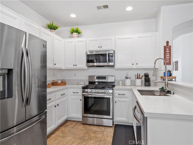 15631 Moccasin Ct, Victorville, CA 92394 - kitchen featuring appliances with stainless steel finishes, a sink, light countertops, white cabinetry, and light tile patterned floors