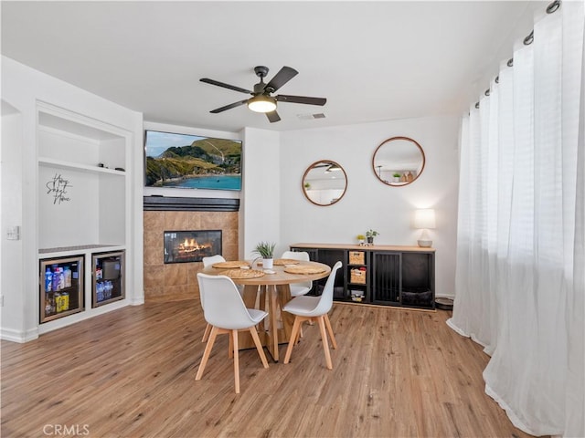15631 Moccasin Ct, Victorville, CA 92394 - dining room with a tile fireplace, wood finished floors, built in features, and a ceiling fan