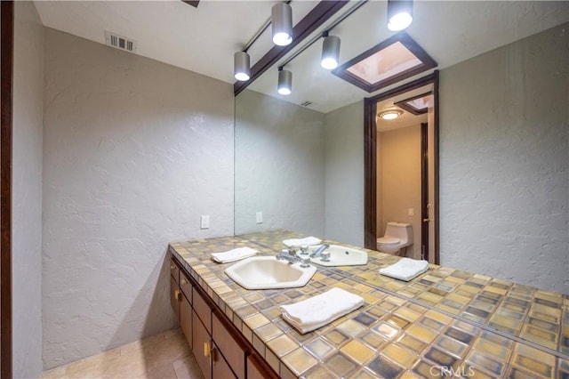 23615 Falcons View Dr, Diamond Bar, CA 91765 - bathroom featuring a textured wall, vanity, and toilet