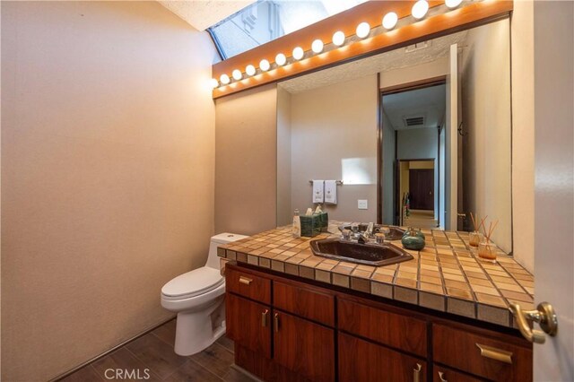 23615 Falcons View Dr, Diamond Bar, CA 91765 - bathroom with a skylight, vanity, toilet, and wood finished floors