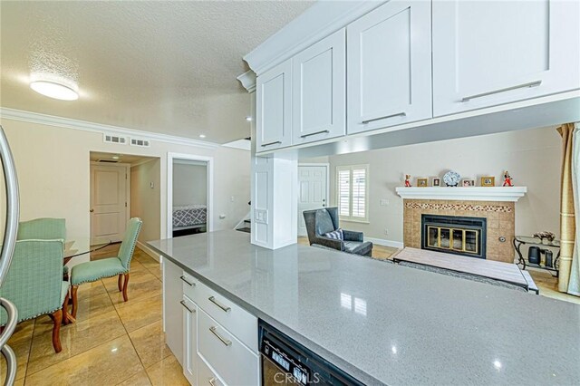 13184 Spire Cir, Chino Hills, CA 91709 - kitchen with white cabinets, light stone counters, a textured ceiling, dishwashing machine, and a tiled fireplace