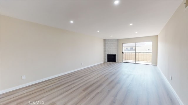 333 Burchett St Unit 203, Glendale, CA 91203 - unfurnished living room featuring light wood-type flooring, recessed lighting, and a brick fireplace