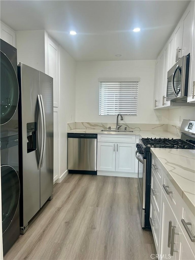 333 Burchett St Unit 203, Glendale, CA 91203 - kitchen with appliances with stainless steel finishes, stacked washer / drying machine, light stone countertops, white cabinets, and recessed lighting