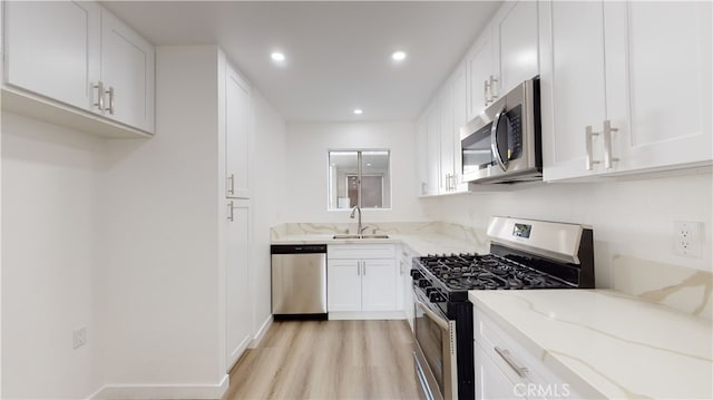 333 Burchett St Unit 203, Glendale, CA 91203 - kitchen with appliances with stainless steel finishes, light stone counters, light wood-style flooring, white cabinetry, and recessed lighting
