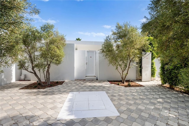 1046 N Hillcrest Rd, Beverly Hills, CA 90210 - doorway to property featuring stucco siding and a patio