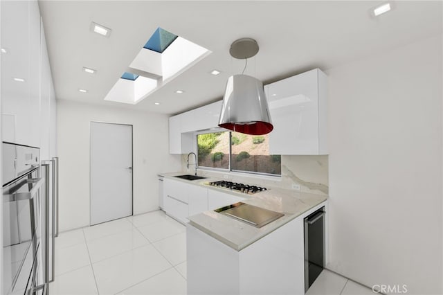 1046 N Hillcrest Rd, Beverly Hills, CA 90210 - kitchen with modern cabinets, a sink, white cabinets, a skylight, and recessed lighting