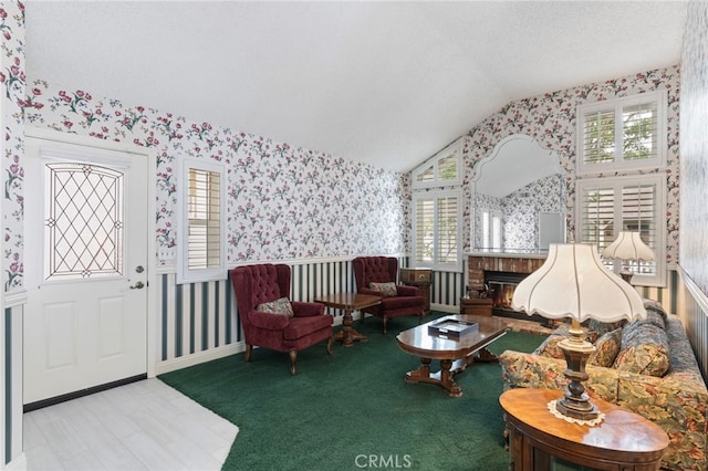 9 Edgestone, Irvine, CA 92606 - living room featuring wallpapered walls, vaulted ceiling, a fireplace, and a textured ceiling