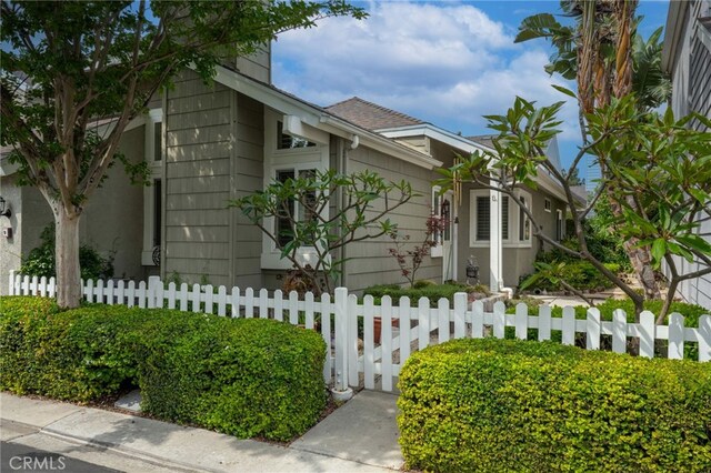 9 Edgestone, Irvine, CA 92606 - view of side of property featuring a fenced front yard and a shingled roof