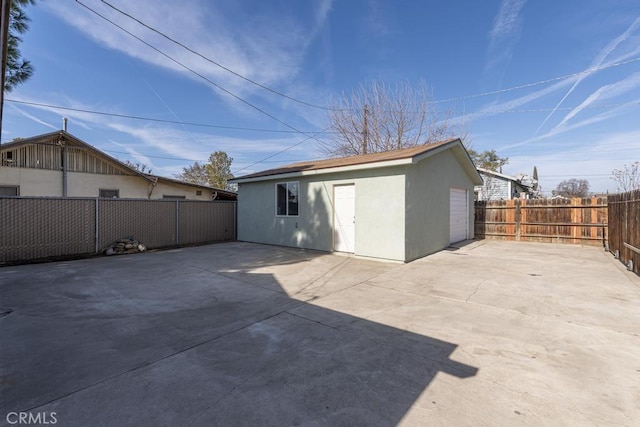 306 Belle Ave, Bakersfield, CA 93308 - back of property featuring an outdoor structure, a fenced backyard, stucco siding, a patio, and a garage