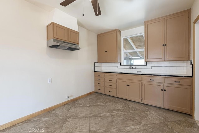 306 Belle Ave, Bakersfield, CA 93308 - kitchen with under cabinet range hood, a ceiling fan, tasteful backsplash, baseboards, and a sink