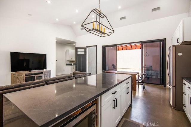 1923119229 Cantara St, Reseda, CA 91335 - kitchen with freestanding refrigerator, white cabinets, dark stone countertops, concrete floors, and hanging light fixtures