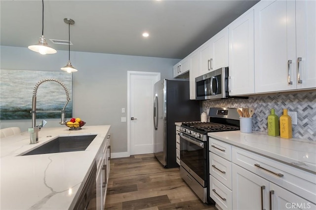 1923119229 Cantara St, Reseda, CA 91335 - kitchen with appliances with stainless steel finishes, a sink, light stone counters, white cabinets, and decorative backsplash