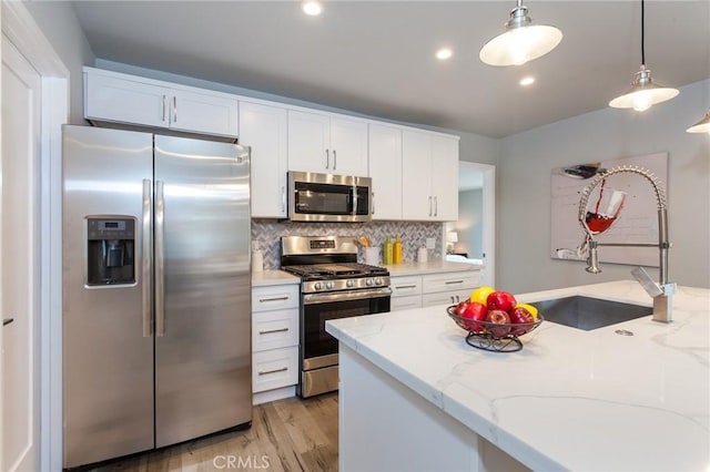 1923119229 Cantara St, Reseda, CA 91335 - kitchen featuring stainless steel appliances, white cabinetry, hanging light fixtures, light stone countertops, and recessed lighting