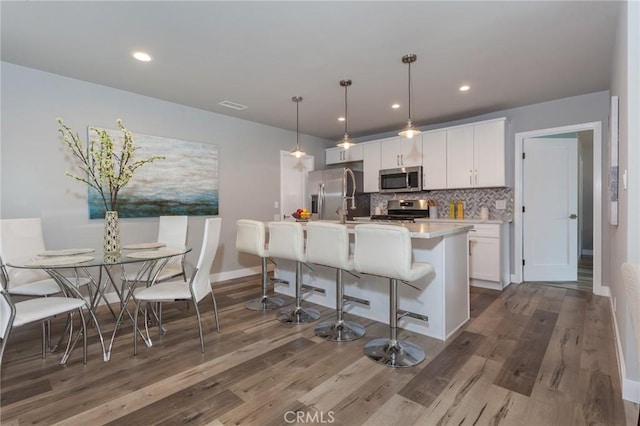 1923119229 Cantara St, Reseda, CA 91335 - kitchen with appliances with stainless steel finishes, white cabinets, dark wood finished floors, tasteful backsplash, and recessed lighting
