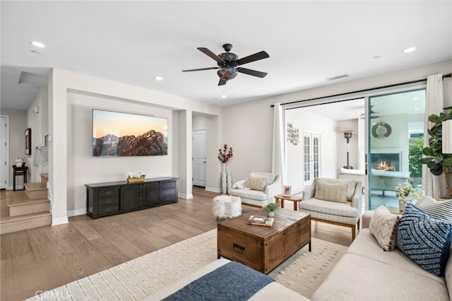 108 Sideways, Irvine, CA 92618 - living room with light wood-style floors, a ceiling fan, stairs, recessed lighting, and a glass covered fireplace