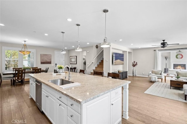 108 Sideways, Irvine, CA 92618 - kitchen featuring recessed lighting, white cabinets, light wood-type flooring, and a kitchen island with sink