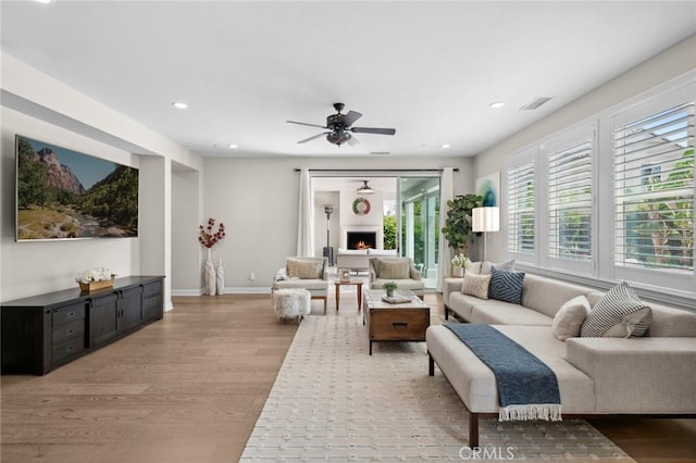 108 Sideways, Irvine, CA 92618 - living room featuring light wood-type flooring, recessed lighting, a ceiling fan, and a warm lit fireplace