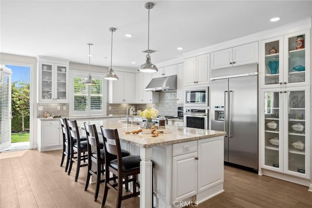 108 Sideways, Irvine, CA 92618 - kitchen with built in appliances, under cabinet range hood, white cabinets, and recessed lighting