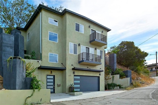 3610 Kinney St, Los Angeles, CA 90065 - view of front of house featuring a balcony, an attached garage, stucco siding, and driveway