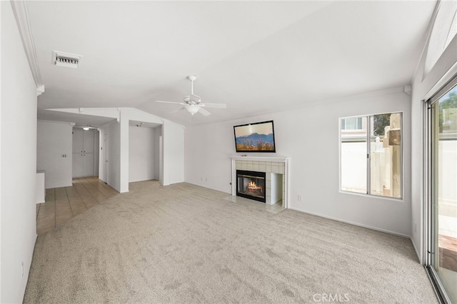 40661 Via Amapola, Murrieta, CA 92562 - unfurnished living room with carpet flooring, a tiled fireplace, ceiling fan, vaulted ceiling, and crown molding