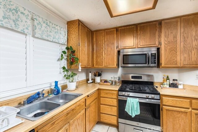 162 Peppertree Way, San Jacinto, CA 92583 - kitchen with stainless steel appliances, light countertops, a sink, and light tile patterned flooring
