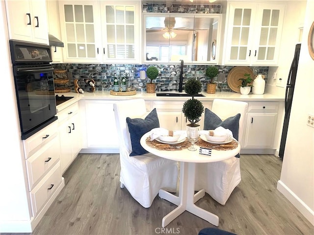 1411 Pelham Rd Unit 664H, Seal Beach, CA 90740 - kitchen featuring oven, a sink, tasteful backsplash, and light wood-style flooring