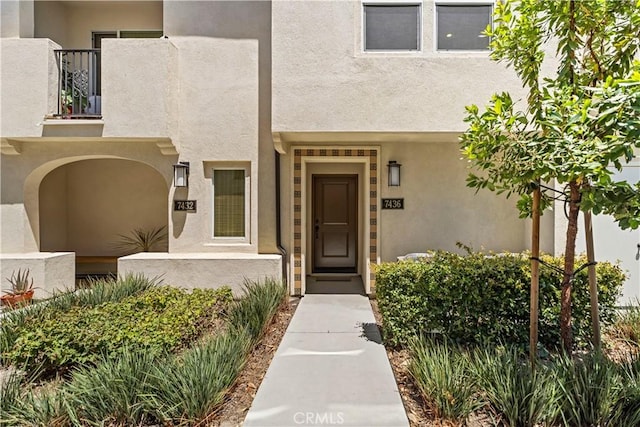 7436 Royal St, Buena Park, CA 90620 - view of exterior entry with a balcony and stucco siding