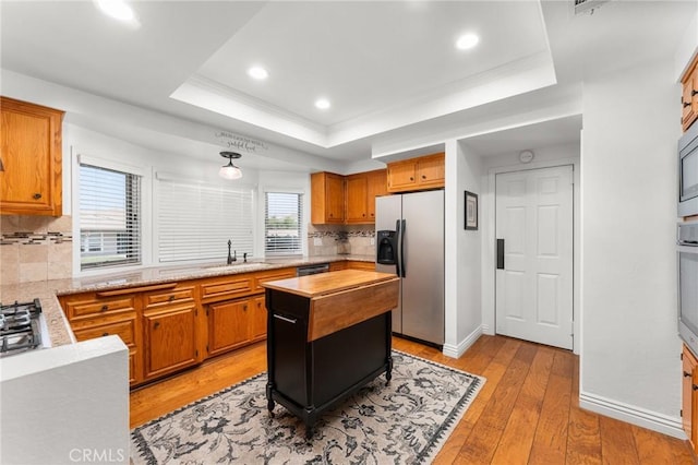 1270 Belle Rd, Calimesa, CA 92320 - kitchen with stainless steel appliances, a sink, a raised ceiling, tasteful backsplash, and light wood-style floors