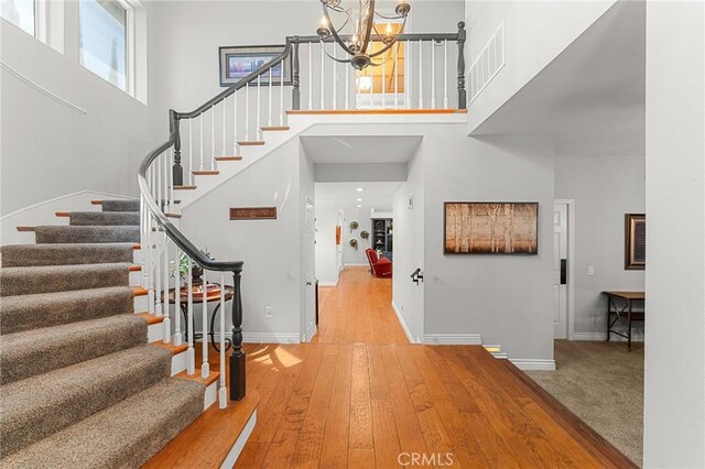 1270 Belle Rd, Calimesa, CA 92320 - foyer with a towering ceiling, stairs, a chandelier, healthy amount of natural light, and wood-type flooring