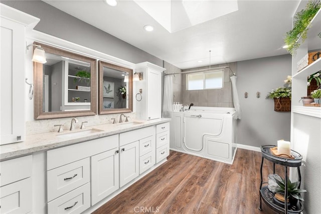 1270 Belle Rd, Calimesa, CA 92320 - full bath featuring double vanity, a skylight, a shower, a bath, and wood finished floors