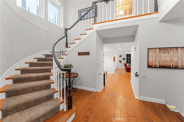 1270 Belle Rd, Calimesa, CA 92320 - stairs with hardwood / wood-style floors, a towering ceiling, and baseboards
