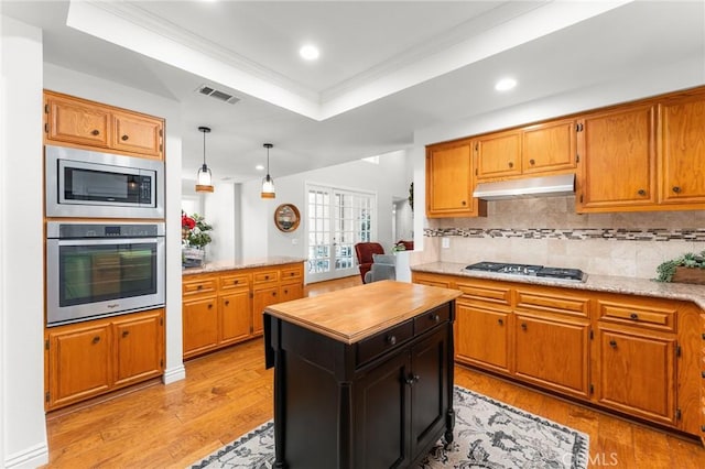 1270 Belle Rd, Calimesa, CA 92320 - kitchen with stainless steel appliances, under cabinet range hood, a raised ceiling, ornamental molding, and tasteful backsplash