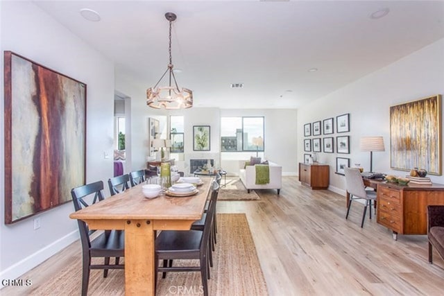 6938 Laurel Canyon Blvd Unit 214, North Hollywood, CA 91605 - dining space with light wood finished floors, a chandelier, and baseboards