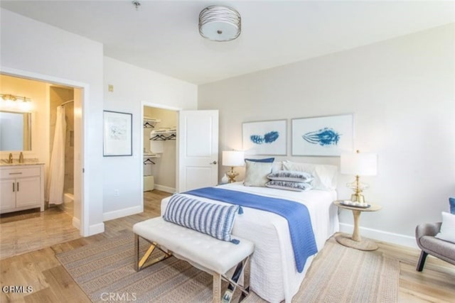 6938 Laurel Canyon Blvd Unit 214, North Hollywood, CA 91605 - bedroom with baseboards, light wood finished floors, a spacious closet, connected bathroom, and a sink