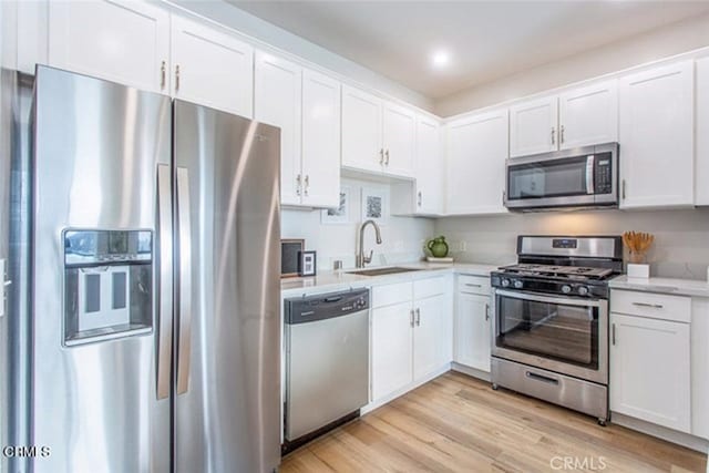 6938 Laurel Canyon Blvd Unit 214, North Hollywood, CA 91605 - kitchen featuring appliances with stainless steel finishes, a sink, white cabinets, and light wood finished floors