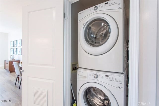 6938 Laurel Canyon Blvd Unit 214, North Hollywood, CA 91605 - laundry area with stacked washing machine and dryer and wood finished floors