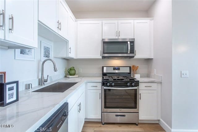 6938 Laurel Canyon Blvd Unit 214, North Hollywood, CA 91605 - kitchen with stainless steel appliances, a sink, light stone counters, and white cabinetry