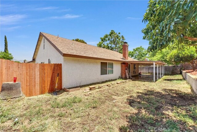 1264 N Mulberry Ave, Rialto, CA 92376 - rear view of property with stucco siding, a chimney, and a fenced backyard