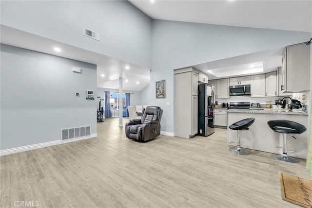 1264 N Mulberry Ave, Rialto, CA 92376 - kitchen with stainless steel appliances, open floor plan, light wood finished floors, recessed lighting, and high vaulted ceiling