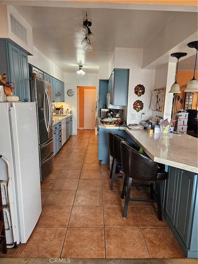2620 2nd Ave Unit 5B, San Diego, CA 92103 - kitchen with freestanding refrigerator, a peninsula, light tile patterned flooring, and blue cabinetry