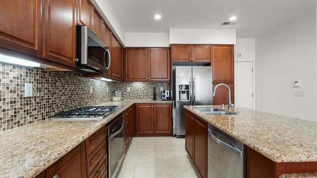 2510 Aperture Cir, San Diego, CA 92108 - kitchen with appliances with stainless steel finishes, a sink, light stone countertops, tasteful backsplash, and light tile patterned floors