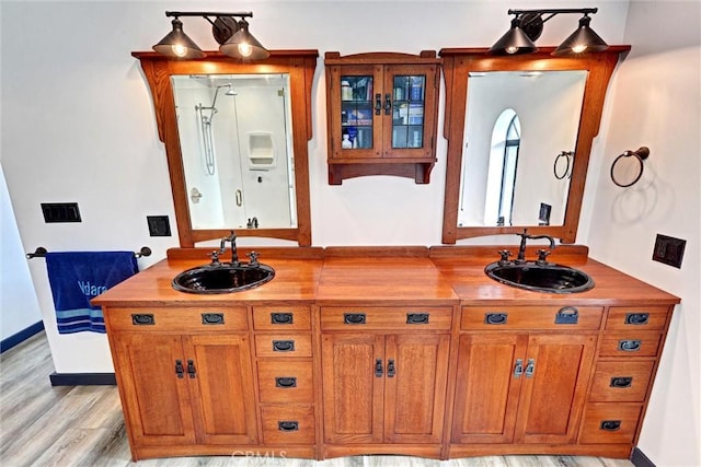 30396 Live Oak Dr, Running Springs, CA 92382 - bathroom featuring wood finished floors, a shower, double vanity, and baseboards