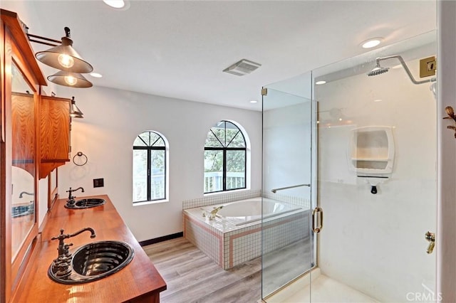 30396 Live Oak Dr, Running Springs, CA 92382 - bathroom featuring a stall shower, a bath, wood finished floors, double vanity, and recessed lighting