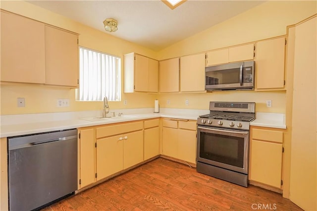 22780 Shawnee Rd, Apple Valley, CA 92308 - kitchen with appliances with stainless steel finishes, a sink, vaulted ceiling, light wood-type flooring, and light countertops