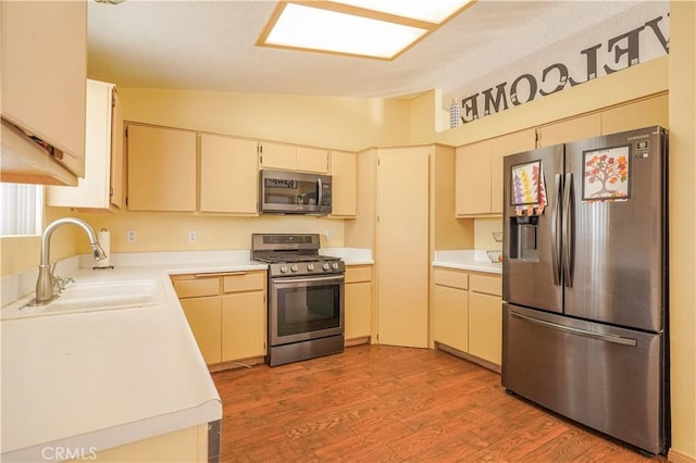 22780 Shawnee Rd, Apple Valley, CA 92308 - kitchen with appliances with stainless steel finishes, a sink, vaulted ceiling, light countertops, and light wood-type flooring